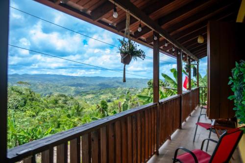 a balcony with chairs and a view of the mountains at Casa de Campo Vista Hermosa in Lares