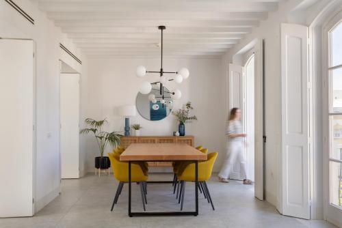 uma sala de jantar com uma mesa e cadeiras amarelas em Candelaria10 em Cádiz