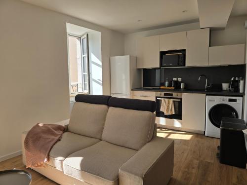 un salon avec un canapé et une cuisine dans l'établissement Casa cosy Lanabat, à Salies-de-Béarn