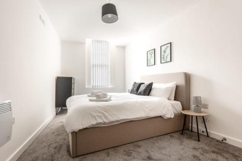 una camera da letto con un grande letto e pareti bianche di Bright 1 Bedroom Apartment in Central Sheffield a Sheffield