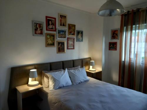 a bedroom with a bed with two lamps and pictures on the wall at Casa do Artista in Vila Verde