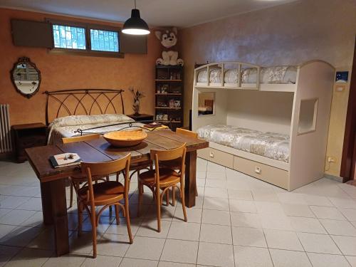 a dining room with a table and a bunk bed at B&B Borgo dei Cedri in Pontecchio