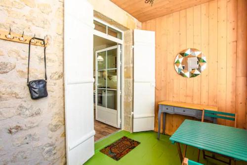 Cette chambre dispose d'une table verte et d'une porte. dans l'établissement L'Elégante - maison de ville avec jardin, à Figeac