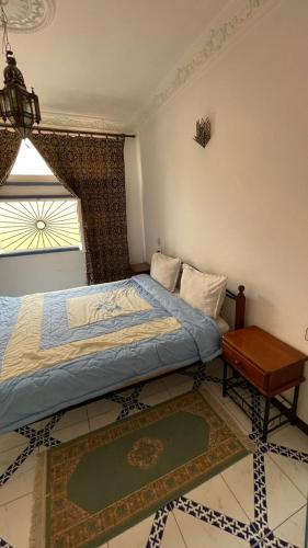 a bedroom with a bed and a table and a window at Residence Koutoubienne in Marrakesh