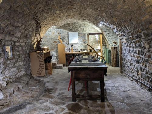 Habitación con una mesa en una pared de piedra. en Ermitage de Peyreleau, en Peyreleau