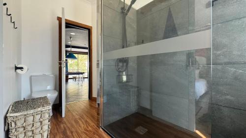a glass shower in a bathroom with a toilet at The Modern & Recycled House in Machico