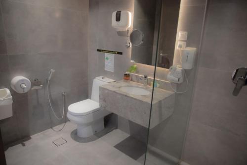 y baño con aseo, lavabo y ducha. en فندق نارس بلس النزهة - Nars Plus Hotel en Yeda