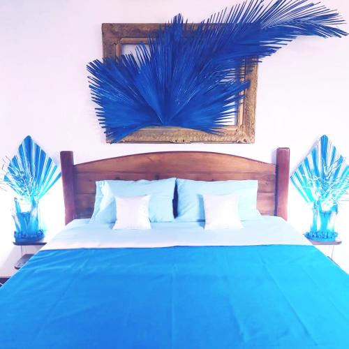a bedroom with a blue bed with blue pillows at Blue Palm Resort Ghana in Abia