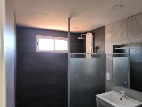 uma casa de banho com um chuveiro e um lavatório. em Chaletpiscina em Benicarló