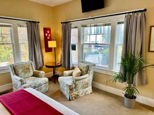 ein Wohnzimmer mit 2 Stühlen und Fenstern in der Unterkunft Bayberry Inn B&B and Oregon Wellness Retreat in Ashland