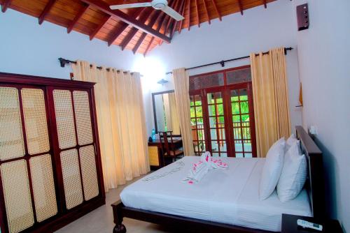 sypialnia z białym łóżkiem i oknem w obiekcie Lagoon Bentota Resort w mieście Bentota