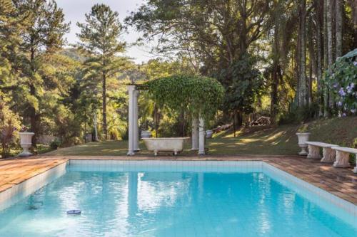 una piscina en un patio con bañera en Casa de Vidro com cachoeira en Itatiba