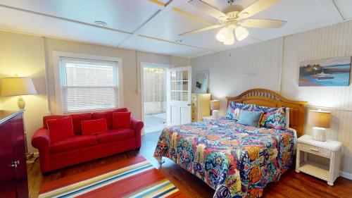 - une chambre avec un lit rouge et une chaise rouge dans l'établissement 4-B 12th Street by Tybee Vacation Rentals, à Tybee Island