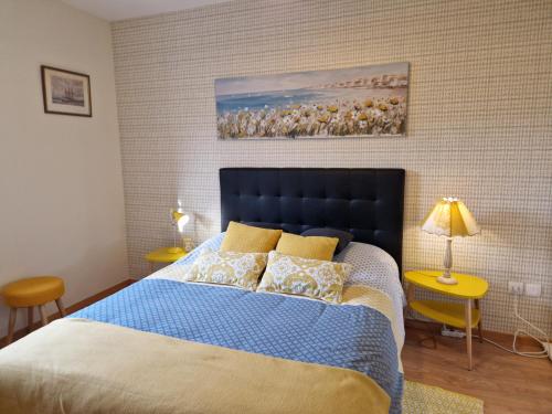 - une chambre avec un lit doté d'une couverture bleue et d'oreillers jaunes dans l'établissement Le Bellem, à Courseulles-sur-Mer