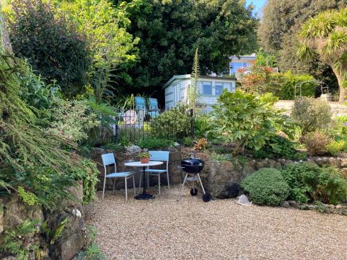un giardino con tavolo, sedie e griglia di Gulls Wing Apartment a Ventnor