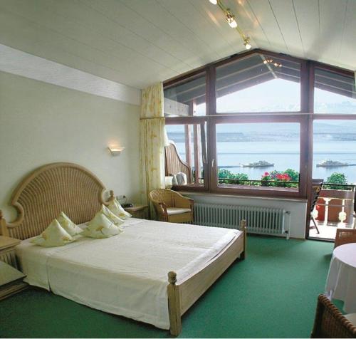 ein Schlafzimmer mit einem Bett und einem großen Fenster in der Unterkunft Weinberghof in Hagnau