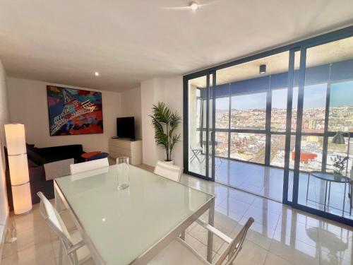 a dining room with a glass table and a living room at 29 Floor. Home Suite Home in Santa Cruz de Tenerife