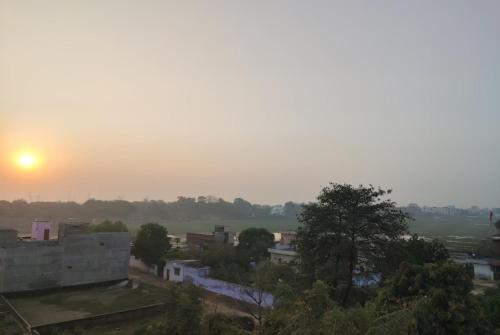uma vista de uma cidade com o pôr-do-sol ao fundo em Goroomgo Hotel Kashi Nest Varanasi - A Peacefull Stay & Parking Facilities em Varanasi