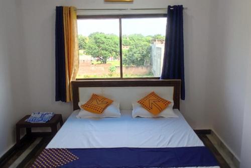 małą sypialnię z łóżkiem z oknem w obiekcie Goroomgo Hotel Kashi Nest Varanasi - A Peacefull Stay & Parking Facilities w mieście Waranasi