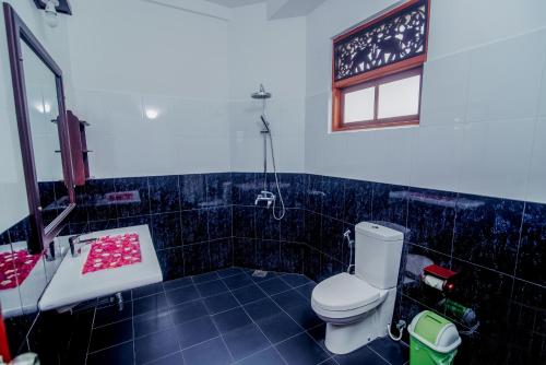 W łazience znajduje się toaleta, umywalka i lustro. w obiekcie Lagoon Bentota Resort w mieście Bentota