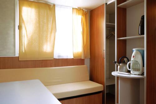 a small kitchen with a bench and a window at Camping Village la Chiocciola in Capannole