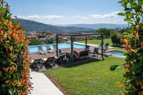 a swimming pool with chairs and a gazebo at Feel Discovery Douro LAS House in Peso da Régua