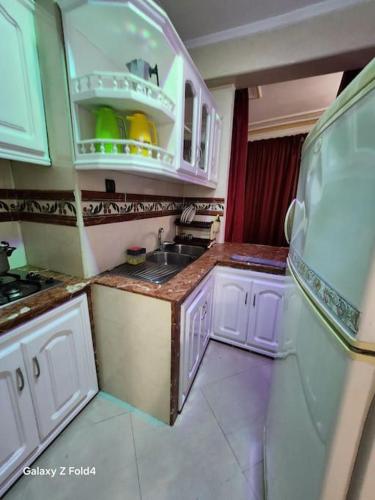 a small kitchen with white cabinets and a sink at complexe printemps n 155 et 3 in Tangier