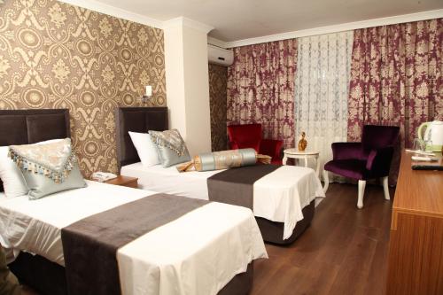 ein Hotelzimmer mit 2 Betten, einem Tisch und Stühlen in der Unterkunft Safir Hotel in Istanbul