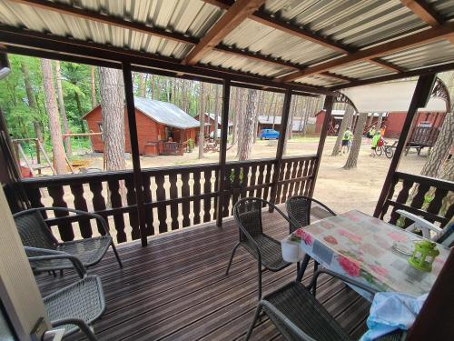 a porch with a table and chairs and a barn at POD SOSNAMI Ośrodek Wypoczynkowy Boszkowo Letnisko in Boszkowo