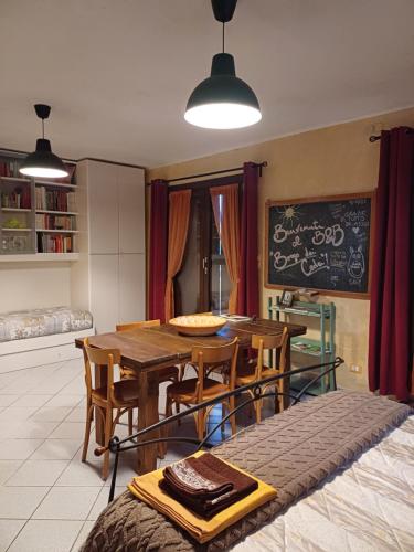 a dining room with a table and chairs and a chalkboard at B&B Borgo dei Cedri in Pontecchio