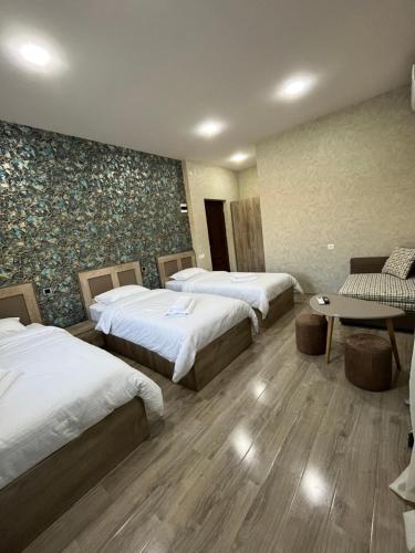 Cette chambre comprend 3 lits et une table. dans l'établissement NAREMA FAMILY HOTEL Meghri, à Meghri