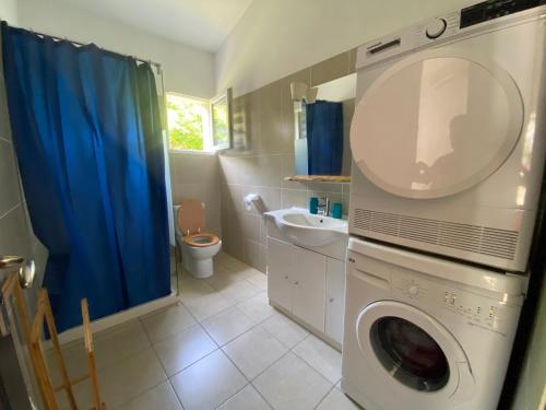uma casa de banho com uma máquina de lavar roupa e um lavatório em chez Béatrice em Porto-Vecchio