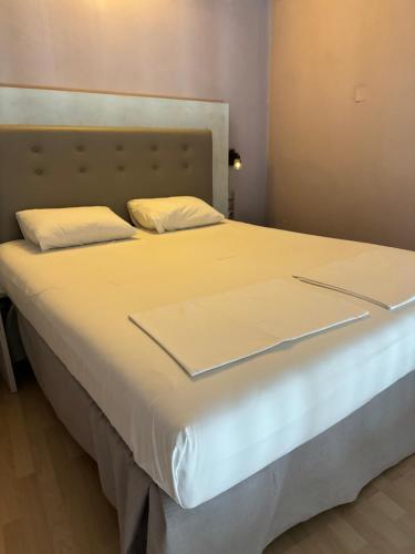 a large white bed with white sheets and pillows at PARALIA Souli di mare in Parga