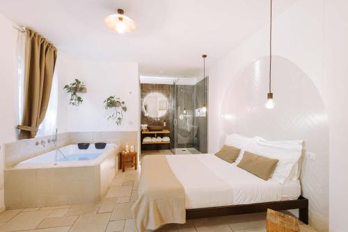 a bedroom with a bed and a bath tub at Dirium - exclusive rooms in Monopoli