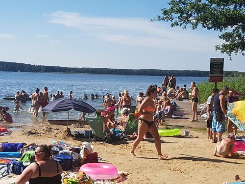 a crowd of people on the beach at the water at POD SOSNAMI Ośrodek Wypoczynkowy Boszkowo Letnisko in Boszkowo
