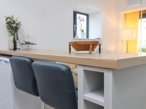 a kitchen counter with two chairs and a table at Ael-y-bryn in Pwllheli