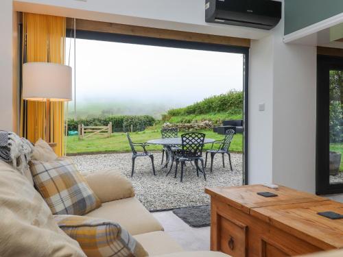 a living room with a couch and a table at Ael-y-bryn in Pwllheli