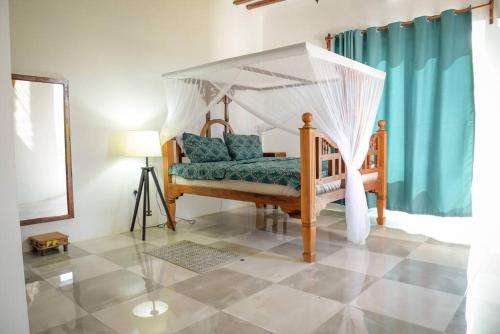 a bedroom with a bed with a canopy at Mkoko Villa in Fumba