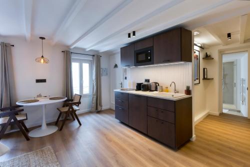 - une cuisine avec un évier et une table dans une chambre dans l'établissement Luxury suite Forville - Cannes center, à Cannes