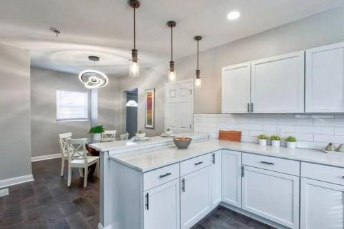uma cozinha com armários brancos e uma mesa de jantar em Windsor Park House em Indianápolis