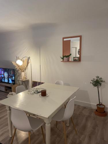 - une table à manger blanche avec des chaises et un miroir dans l'établissement Magnifique appartement Brest, à Brest