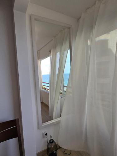 a room with a mirror and a window with the ocean at Apartamento Mar y Paz 15 in Calpe