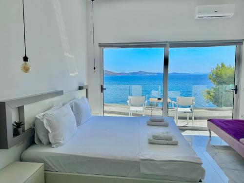 a bedroom with a bed and a view of the ocean at Sea Horizon Vsl Suites & Apartments in Sarandë