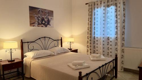 a bedroom with a bed with two towels on it at Aegean Balcony in Ano Meria