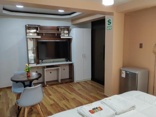 1 dormitorio con cama, mesa y TV en Hotel Los Inkas, en Huaraz