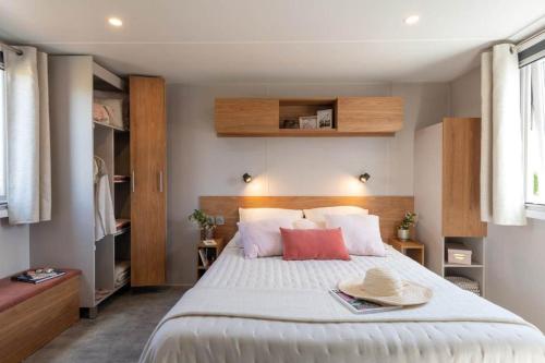 ein Schlafzimmer mit einem großen Bett mit zwei Hüten darauf in der Unterkunft Vakantiehuis Hoge Kempen - 25 minuten Roermond, Maasmechelen & Maastricht in Kinrooi