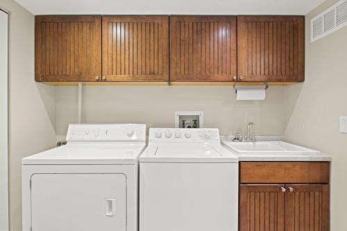 uma cozinha com um frigorífico branco e um lavatório em Luxury Conesus Lakeside Dock Modern Amenities em Livonia