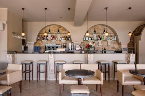 um restaurante com mesas e cadeiras e um bar em Hotel Apollon Corfu em Paleokastritsa