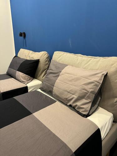 two beds in a room with a blue wall at Black Room & Breakfast in Bari