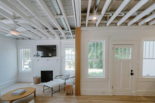 a living room with white walls and a fireplace at Villa Marguerita by WB Abodes in Wrightsville Beach
